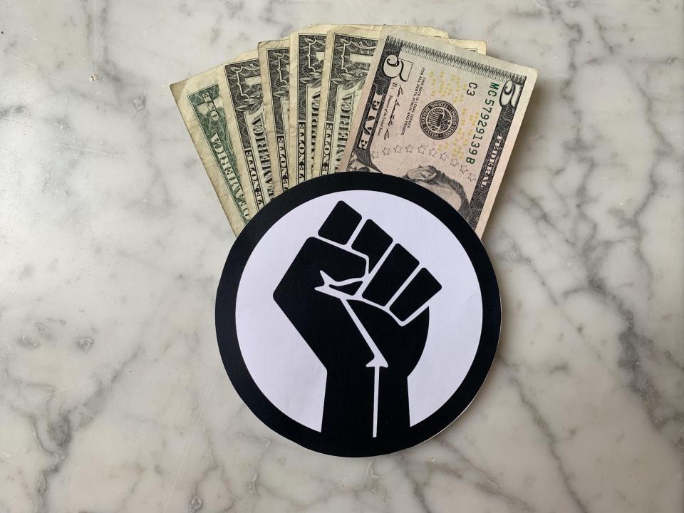 黑人权力的拳头用金钱从上面出来的象征
